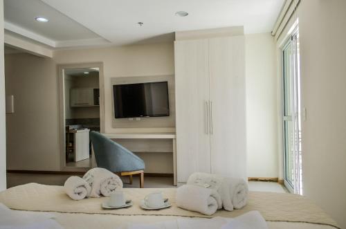 伊塔库鲁Porto Marina Mont Blanc Itacuruçá的客房设有带毛巾的床和电视。