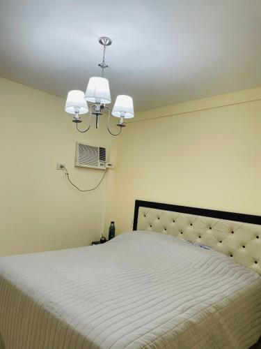 雷西斯膝西亚Temporarios Chaco的一间卧室配有一张床和一个吊灯