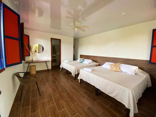 蒙特内哥罗Cabaña Quindiana - Excelente Ubicación的酒店客房设有两张床和一张桌子。