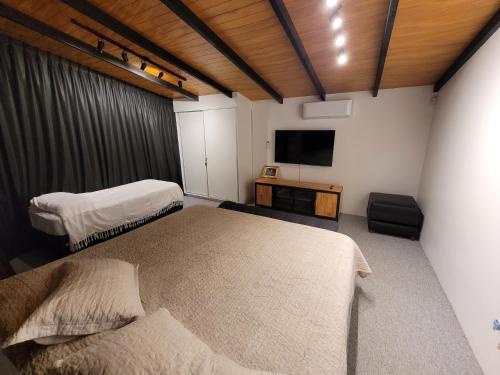 波萨达斯Casa sobre el río的一间卧室配有两张床和一台平面电视