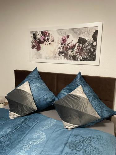 奥伯豪森Paris3的一张带两个枕头的床和一张墙上的照片