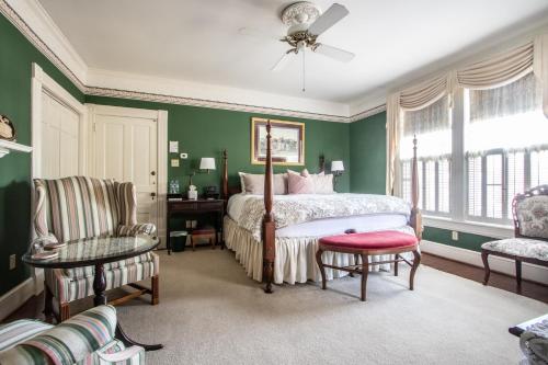 克里斯琴斯堡The Oaks Victorian Inn的一间卧室设有绿色的墙壁、一张床和椅子