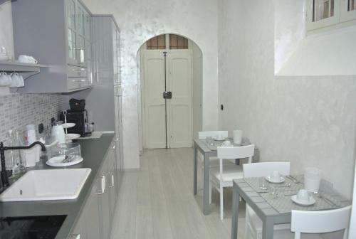 罗马雅邦岛住宿加早餐旅馆的白色的厨房,配有2张桌子和白色的门