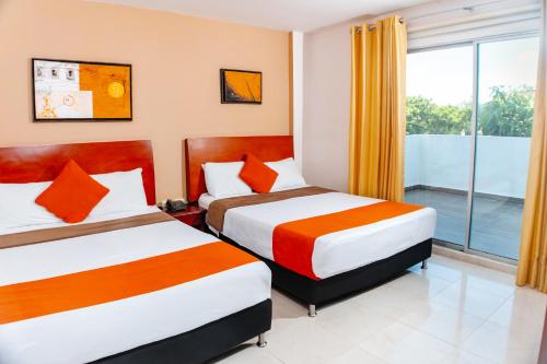 库库塔Hotel Luxor Cúcuta的酒店客房设有两张床和窗户。