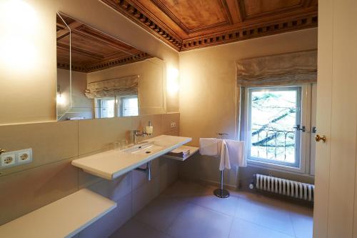 阿皮亚诺苏拉斯特拉达Schloss Englar的一间带水槽和镜子的浴室以及窗户。