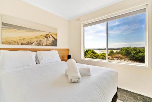 科尔斯湾蔚蓝度假屋的卧室配有一张大白色床和窗户
