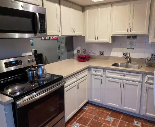 迈阿密Beds & Sheets DOWNTOWN的厨房配有白色橱柜和炉灶烤箱。