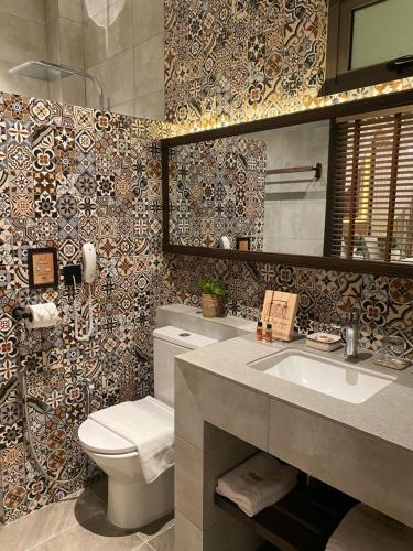 乔治市克兰坦旅馆的一间带卫生间、水槽和镜子的浴室