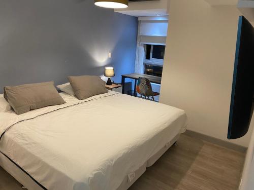 利马Moderno departamento Miraflores 360的卧室配有白色的床和书桌