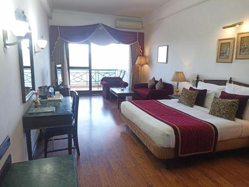 卡绍利Kasauli Resort by Piccadily的酒店客房设有一张大床和一张书桌。