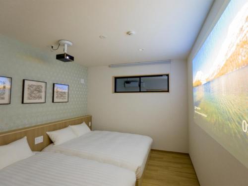 日光Rakuten STAY Nikko Hoden Capacity of 8 persons的一间卧室设有两张床和大屏幕