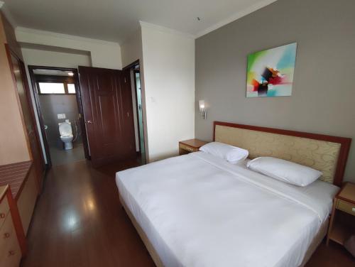 伯恩仓Sunrise View One Bedroom Apartment at Equatorial Hill Resort的卧室配有一张白色大床