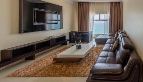 迪巴Dibba Sea View Hotel by AMA Pro的客厅配有真皮沙发和电视