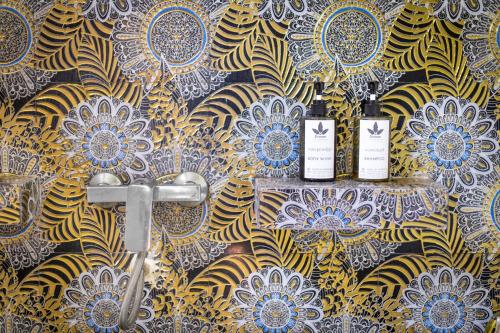 Phumĭ Réach Born (2)Banana Resort, le petit nid de Caro的浴室的墙上装有两瓶葡萄酒