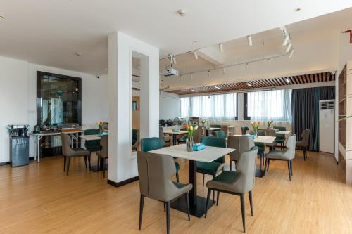 广州希岸·轻雅酒店(广州芳村花地湾地铁站店)的用餐室配有桌椅