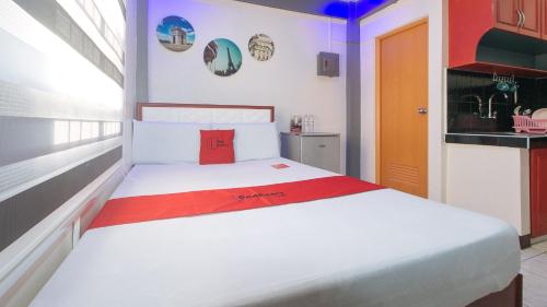 马尼拉RedDoorz A&F C5 Pinagsama Taguig的卧室配有白色的床和红色枕头