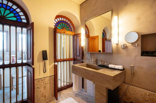 沙迦The Chedi Al Bait, Sharjah的一间带水槽和彩色玻璃窗的浴室