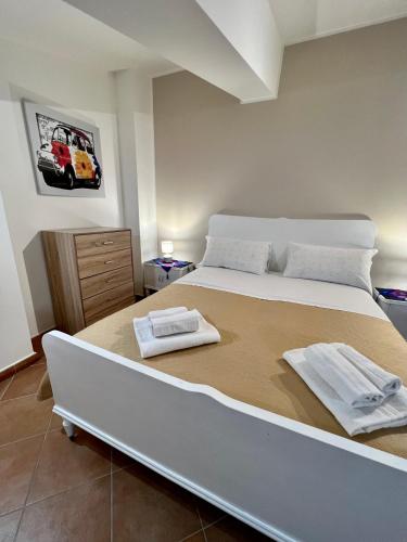 墨西拿Sicilia Bedda Apartment的一间卧室配有一张大床和两条毛巾