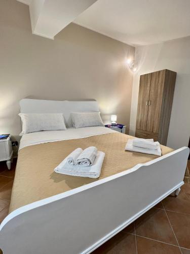墨西拿Sicilia Bedda Apartment的一间卧室配有一张大床和毛巾