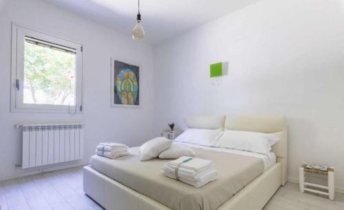 Castri di LecceLa Dimora dei Gelsi的白色卧室,配有带毛巾的床