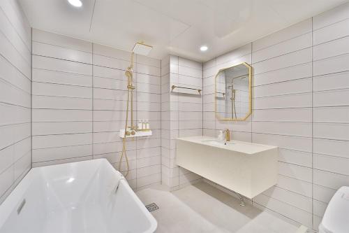 庆州Hotel Palace Gyeongju的白色的浴室设有水槽和镜子