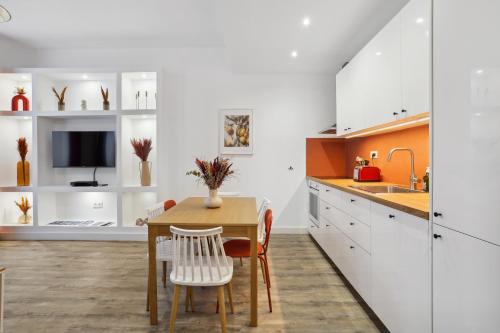 马赛Le confort d'un T3 climatisé en plein coeur de Marseille的厨房配有白色橱柜和桌椅
