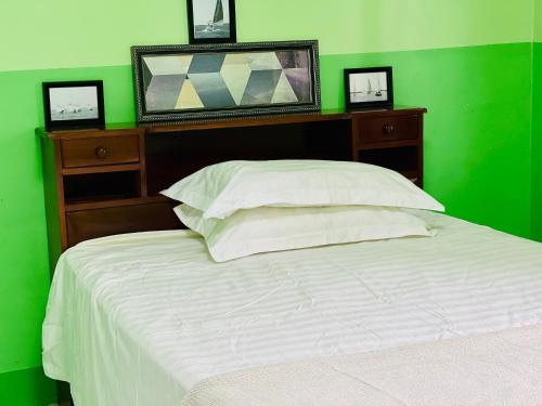 苏瓦Grace house的绿色卧室设有白色的床和绿色的墙壁