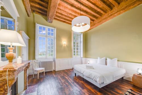 BretenièreÉcrin exclusif au sein d'un château en Bourgogne的卧室设有白色的床和木制天花板。