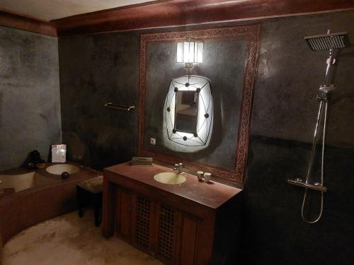 马拉喀什Riad Jenaï L'Authentique的浴室配有盥洗盆、镜子和浴缸