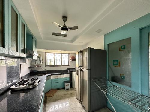 孟买Welcome Home Service Apartments - Andheri的厨房配有不锈钢冰箱和蓝色橱柜