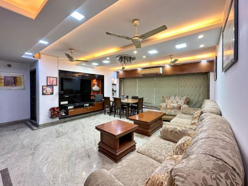 孟买Welcome Home Service Apartments - Andheri的客厅配有沙发和桌子