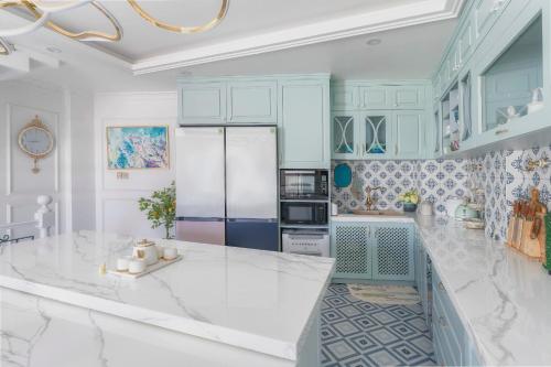 大叻Súp Lơ House (Broccoli's House)的厨房配有蓝色橱柜和白色台面