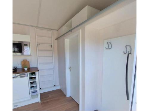 武斯特马克Tiny House Paradies的一间设有白色门的房间和一间厨房