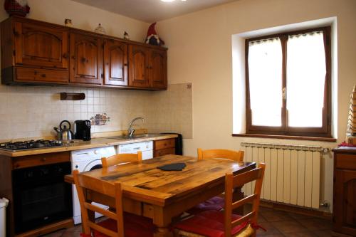 阿贝托内Chalet Abetone in Tuscany的厨房配有木桌、椅子和水槽