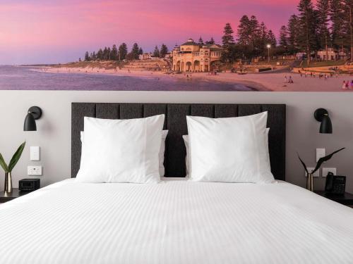 珀斯Novotel Perth Murray Street的一间带白色床的卧室和一个带房子的海滩