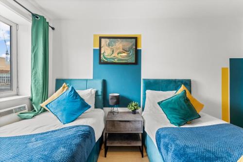 布里斯托Enchanting Bristol Abode -Sleeps 6 with Balcony!的蓝色和白色的客房内的两张床