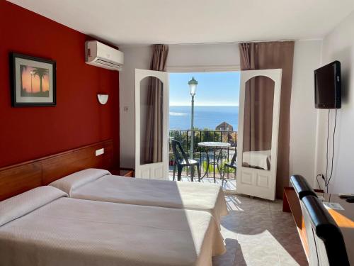 马罗巴尔肯德马洛公寓式酒店的一间卧室配有一张床,享有海景