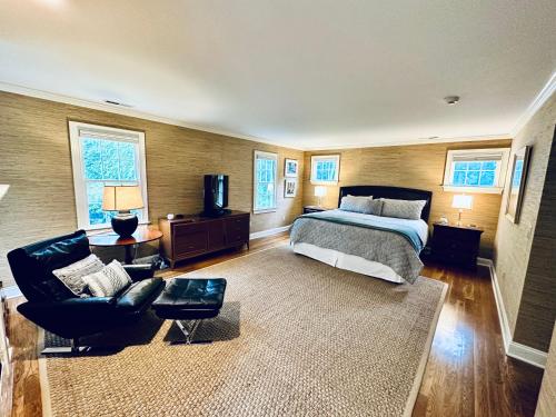 WashingtonUpmarket Country Retreat, Washington, Connecticut的一间卧室配有一张床、一张沙发和一把椅子