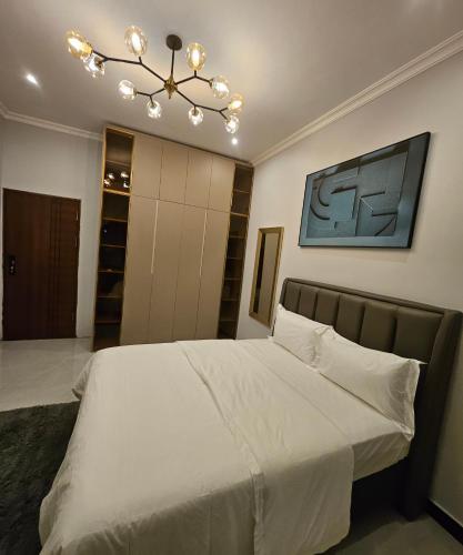 KitweVk apartments的卧室配有白色的床和吊灯。
