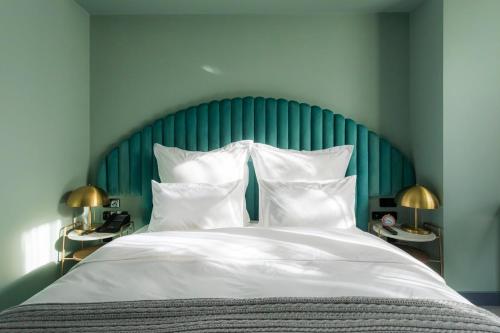 第比利斯Khedi Hotel by Ginza Project的一张带绿色床头板和白色枕头的床
