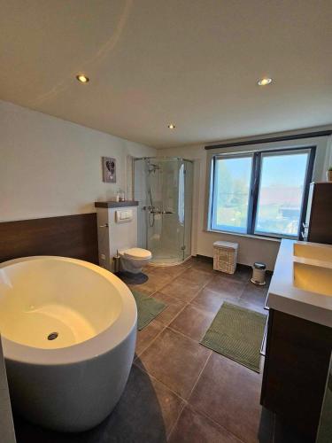 圣特雷登Stadsparel Sint-Truiden的大型浴室设有大浴缸和卫生间。