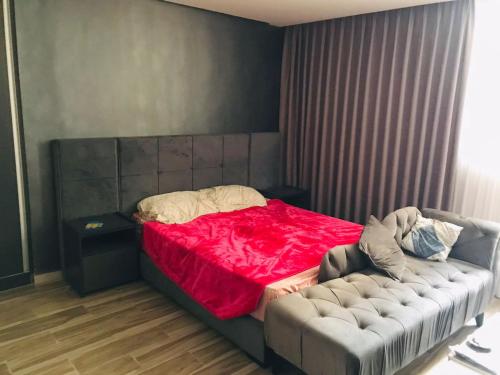 安曼مجمع الجاردنز افينيو的一间卧室配有一张带红色毯子的床和一张沙发