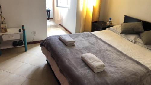 帕斯托ERY total confort Pasto apto的一间卧室配有一张大床和两条毛巾
