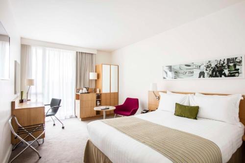 利兹希尔顿利兹双树酒店的配有一张床和一张书桌的酒店客房