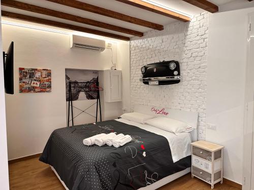 米兰CA.FOSCARI的卧室配有1张床和1台砖墙电视