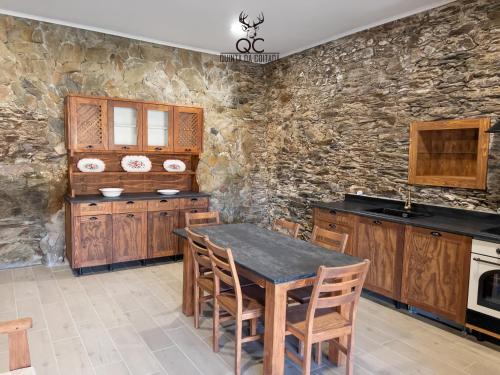 Soutelo do DouroQuinta da Coitada - Alojamento Local的厨房配有桌子和石墙