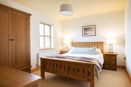 CarrigartDonegal Boardwalk Resort的一间卧室配有一张带2个床头柜和2盏灯的床。