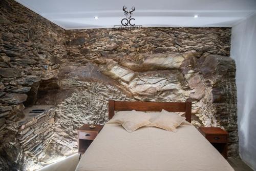 Soutelo do DouroQuinta da Coitada - Alojamento Local的一间卧室设有石墙和床