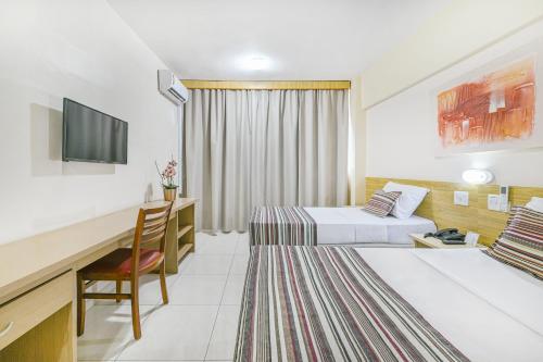 皮拉西卡巴Hotel Nacional Inn Piracicaba的酒店客房配有两张床和一张书桌