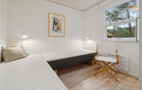 维斯特索马肯Stunning Home In Nex With Kitchen的一间卧室设有两张床、一张桌子和一个窗口。